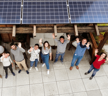Equipo de Ecooo bajo unos paneles solares